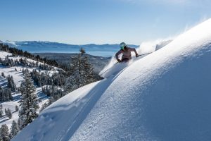 Featured image showing a skier at Alpine Meadows Ski Resort enjoying a powder day with Lake Tahoe in the background.