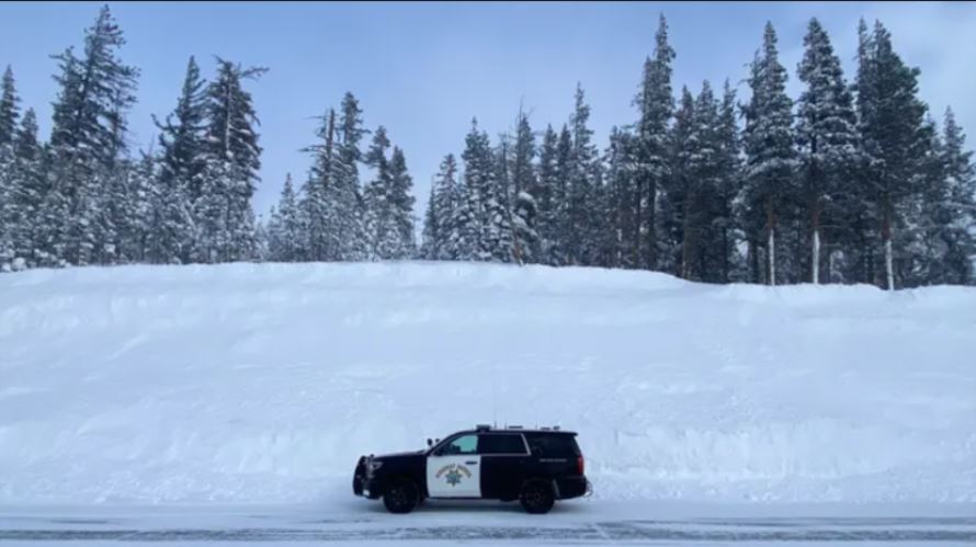 Featured image showing a California Highway Patrol vehicle parked along a massive snowbank at Interstate 80's Donner Summit on March 1, 2023.