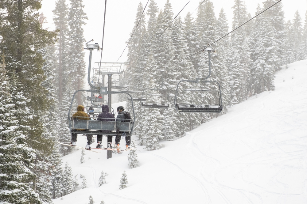 Featured image showing three skiers on a Chairlift during a winter storm, at Northstar Ski Resort, Truckee, CA