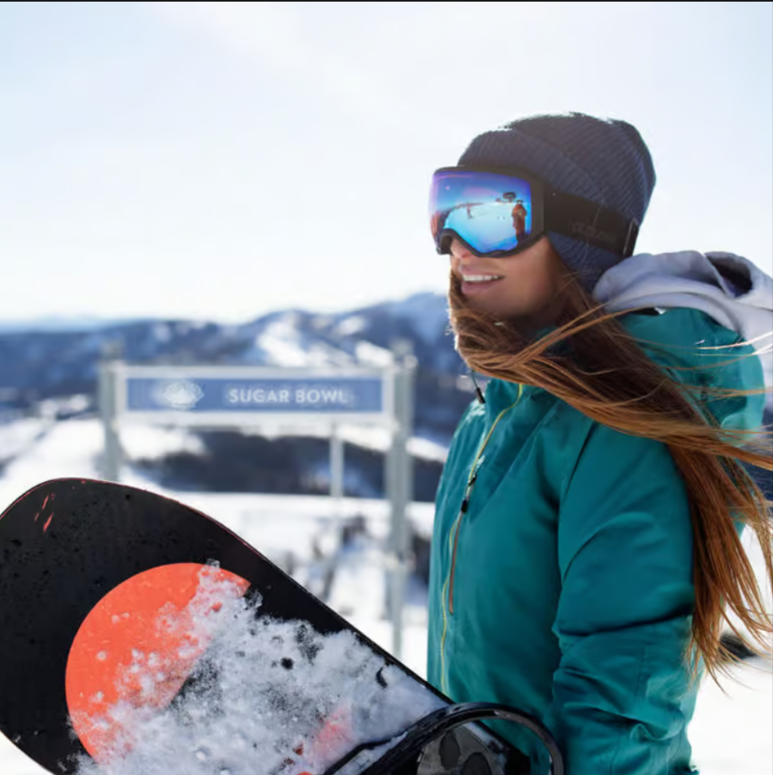 Featured images showing a young woman snowboarder, in googles holding a snow covered board at Sugar Bowl Resort.